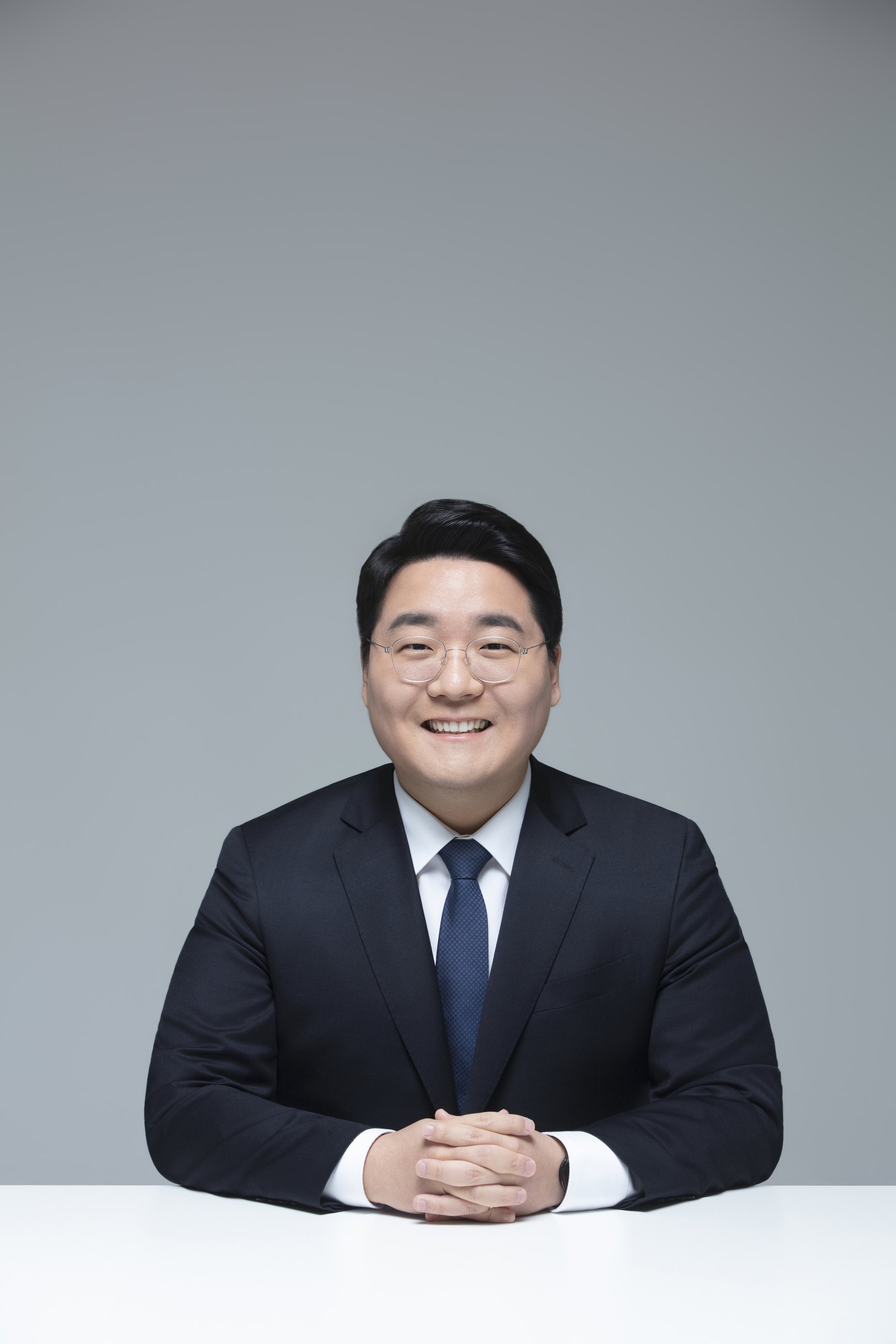 책상에 앉아 미소 짓는 이동현 후보
